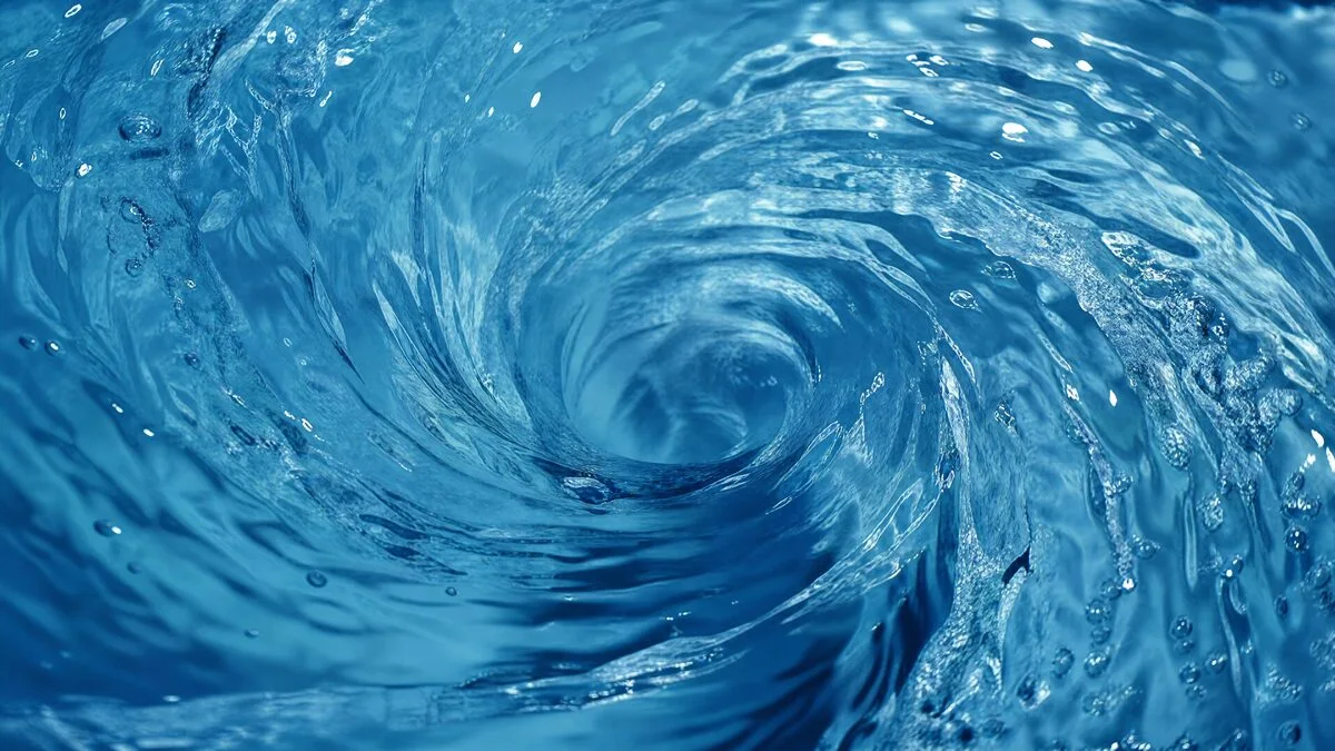Clear blue water forming a spiral vortex in an industrial fluid-motion image