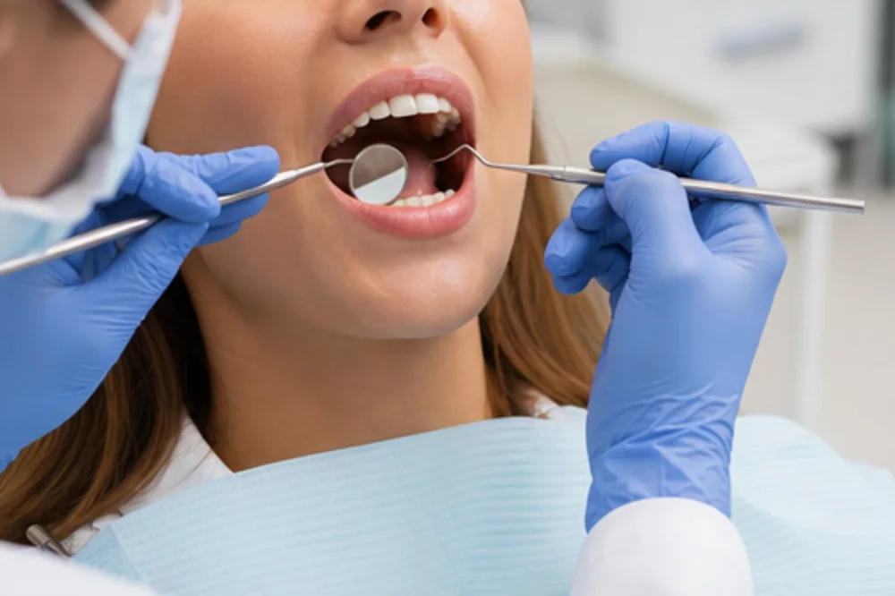 Dentist using a dental mirror and probe during an oral examination